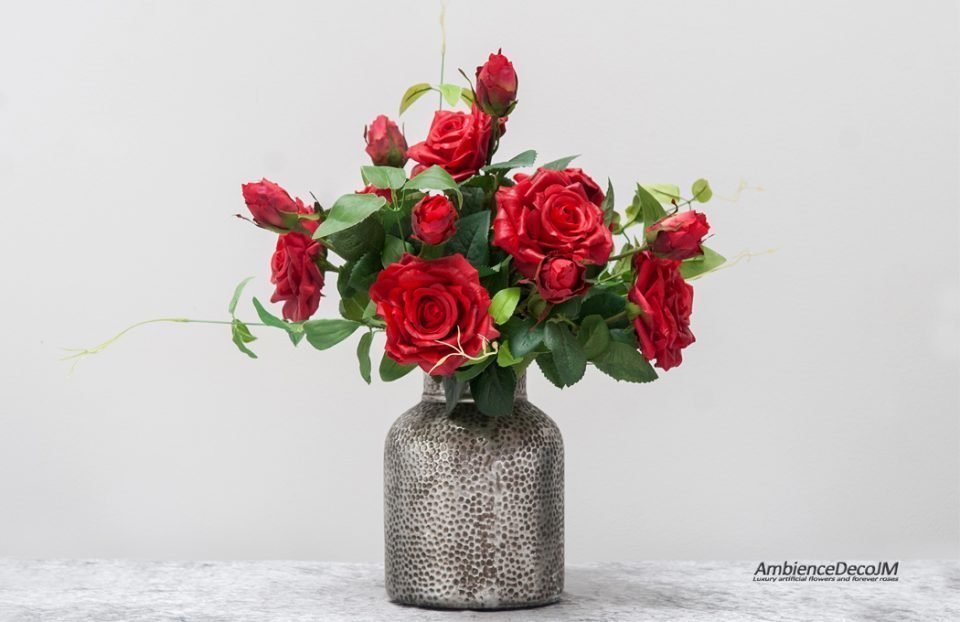 Red lifelike roses in vase